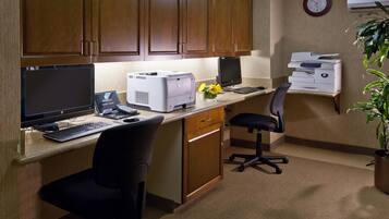 A home office with a desktop computer, printer, and office chair.