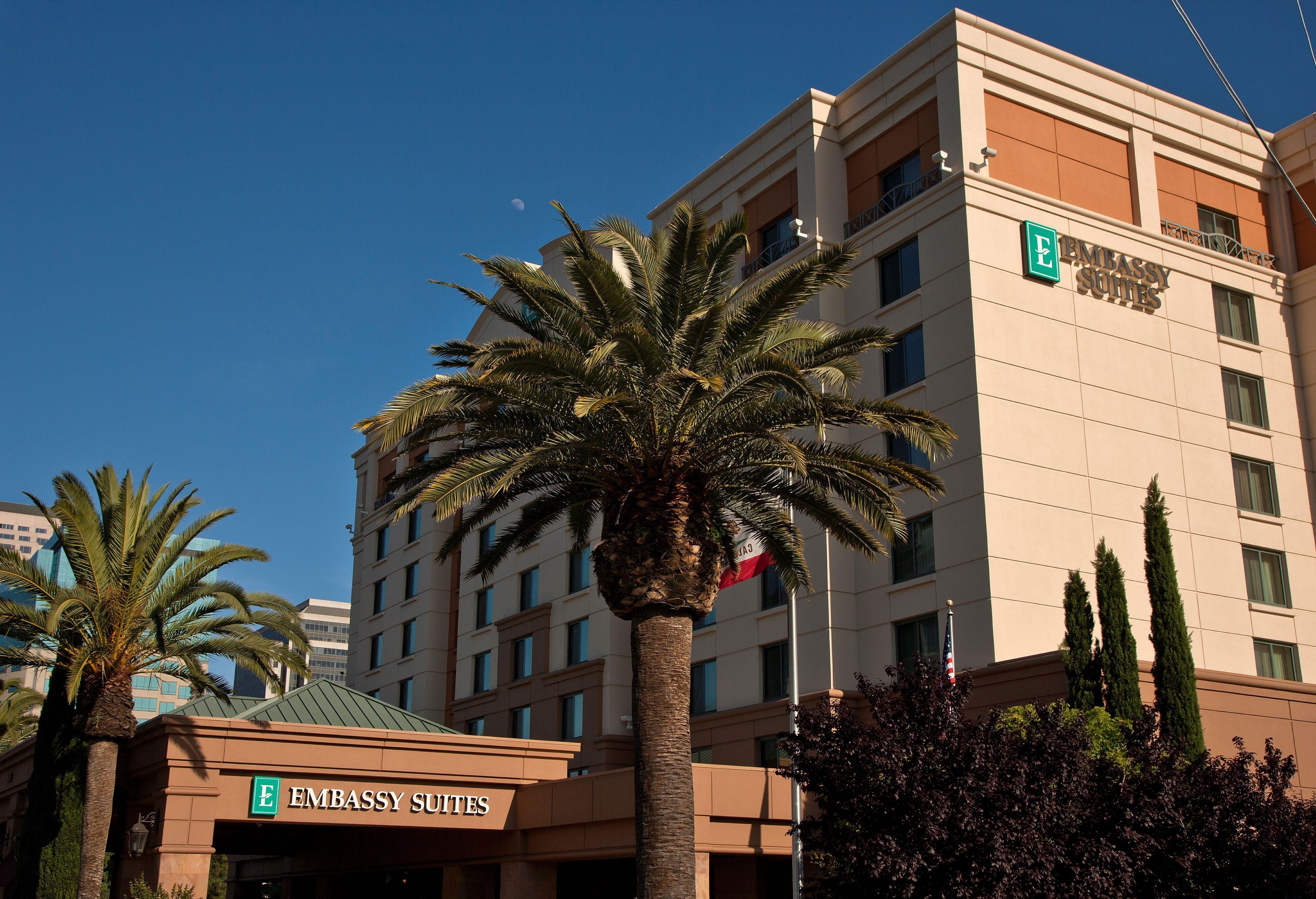 A multi-story building with a sign for 'Embassy Suites.'