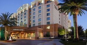 A multi-story hotel with 'EMBASSY SUITES' signage, a parking lot, and palm trees. - Embassy Suites by Hilton Sacramento Riverfront Promenade (Sacramento)