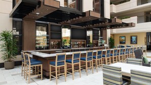 A bar area with a long counter, multiple bar stools, and a seating area with tables and chairs.