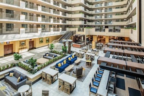 A multi-level hotel atrium with outdoor seating, a staircase, and a bar area. - Embassy Suites by Hilton Sacramento Riverfront Promenade (Sacramento)