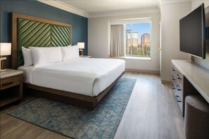 Relax in comfort with a large bed, nightstand, and TV, plus a city view from the large window.