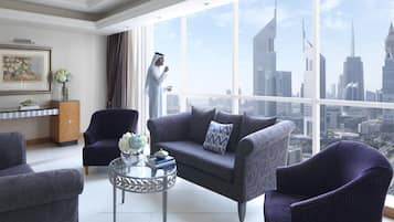 Una sala de estar moderna con vistas a la ciudad, un sofá, sillones, una mesa de centro de vidrio y un jarrón decorativo.