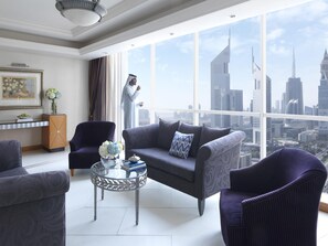 A modern living room with a city view, a sofa, armchairs, a glass coffee table, and a decorative vase. - Fairmont Dubai (Dubai)