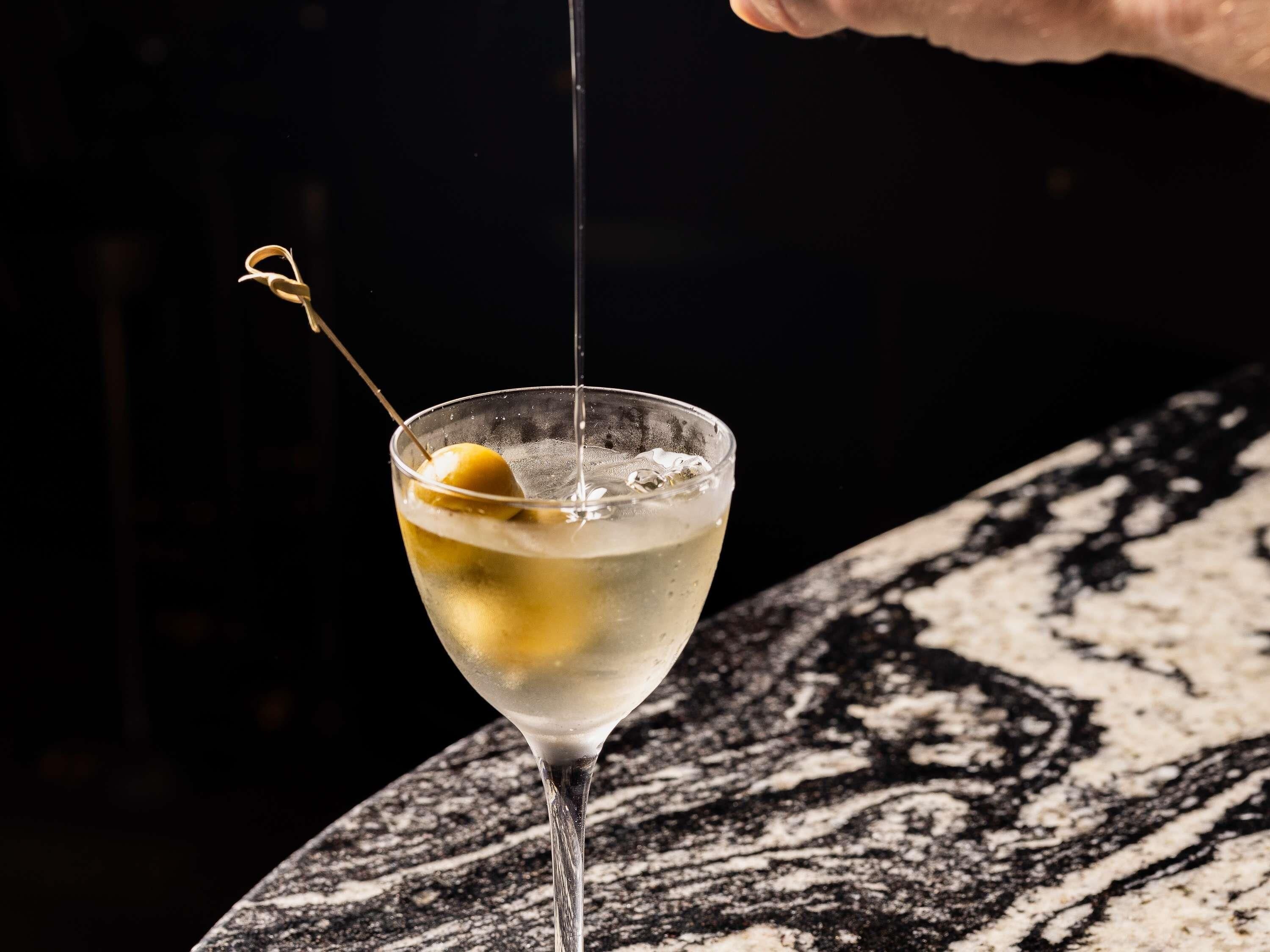 A cocktail with a garnish and ice in a clear glass.