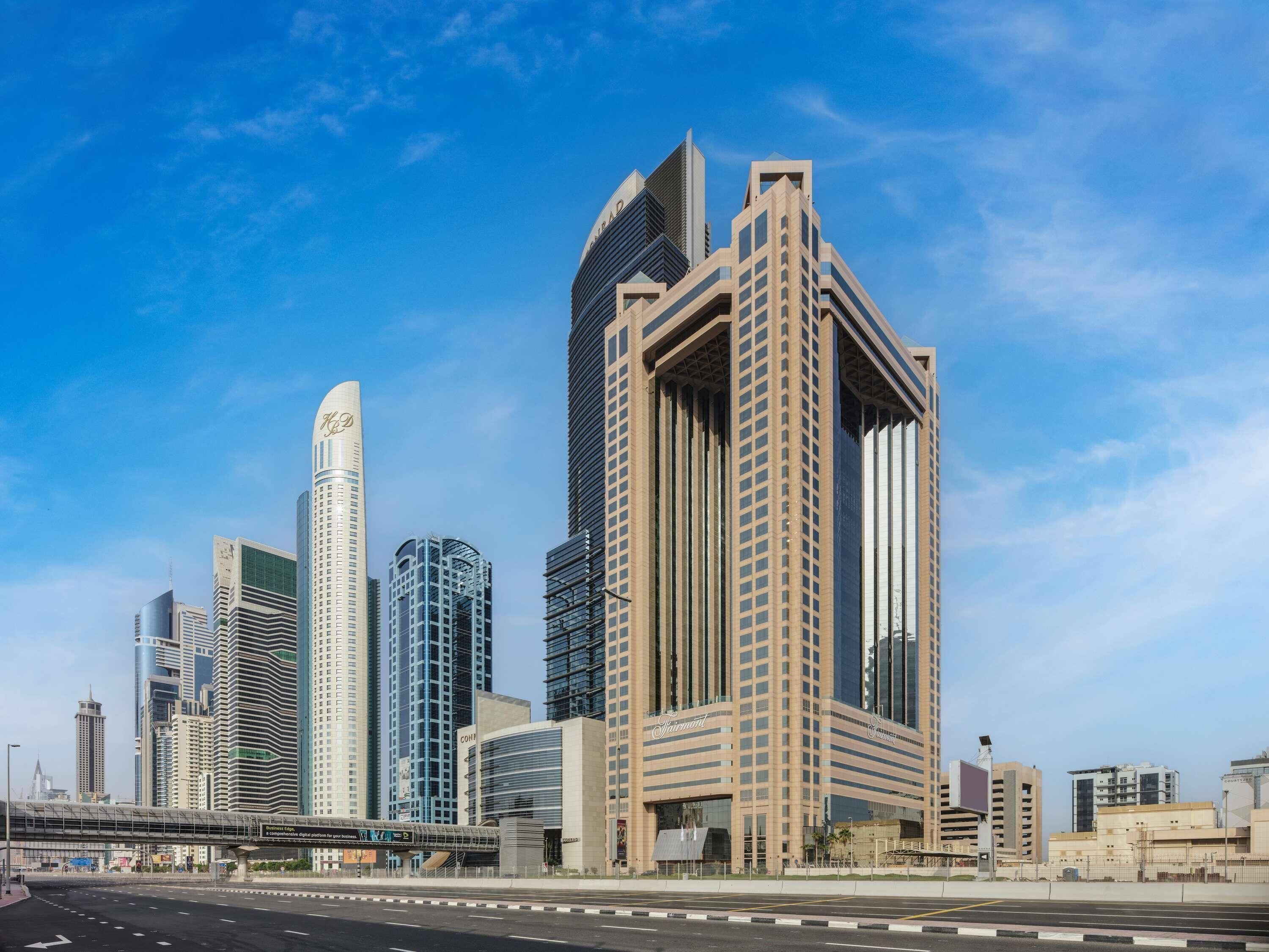 A modern high-rise hotel with a prominent curved facade, multiple floors, and a large entrance.