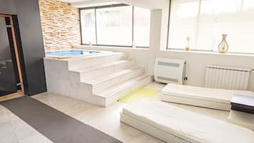 Relax in a comfortable space with a hot tub, sofa, and radiator for a cozy retreat.