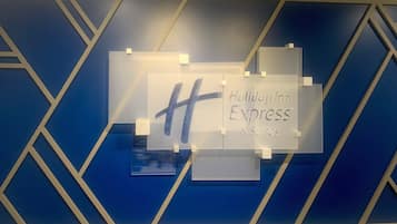 Een muur met een geometrisch patroon en een bord met Holiday Inn Express & Suites.
