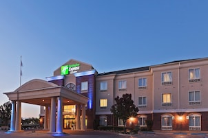 Edificio de Holiday Inn Express & Suites con entrada cubierta y múltiples ventanas.