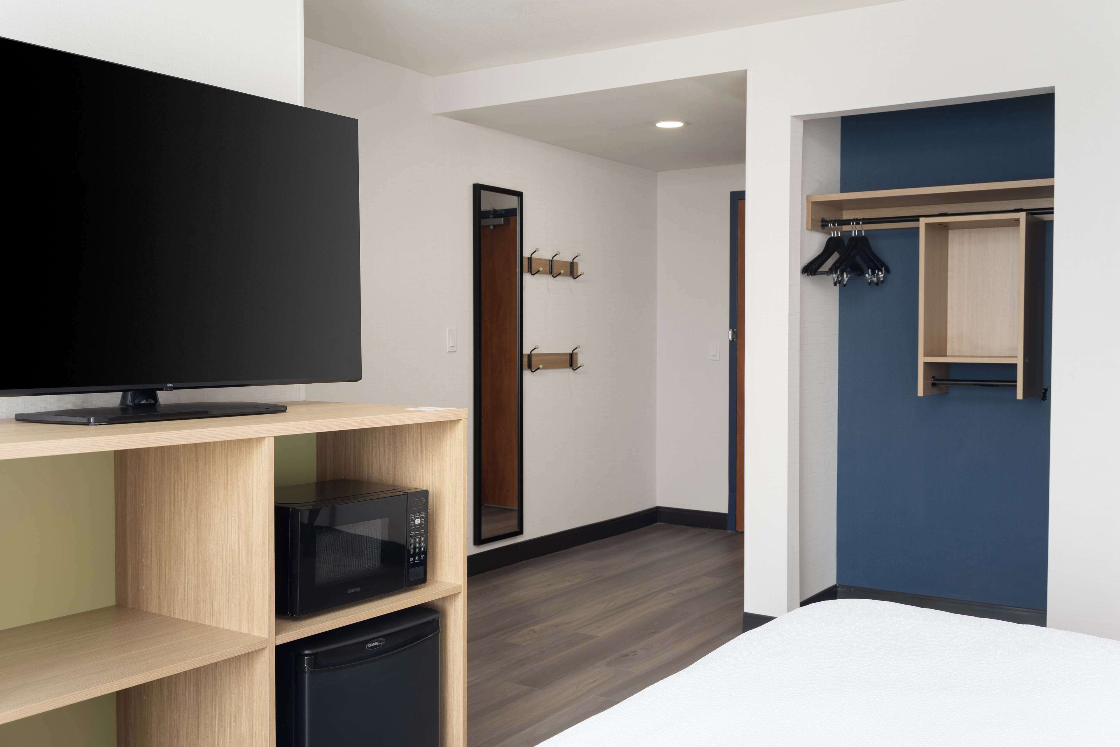 Hotellihuoneessa on litteänäyttöinen televisio, joka on sijoitettu puuhyllylle, mikroaaltouuni ja pieni jääkaappi. Huoneessa on myös peilillä varustettu ovi sekä naulakko, jossa on henkareita.