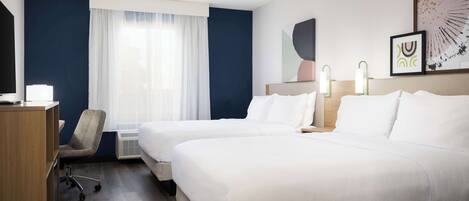 A hotel room with two beds, a desk, a chair, and a large window with curtains.
