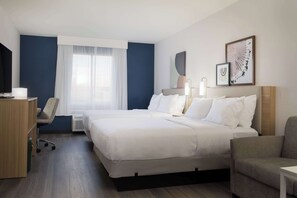A hotel room with a large bed, a desk, a chair, and a TV. - Spark by Hilton Guelph (Guelph)