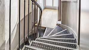 A staircase with patterned carpet leading to a landing. - Chabrol Opéra (Paris)