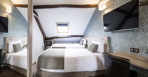 A hotel room with two beds, a TV, a small window, and a wooden ceiling. - Chabrol Opéra (Paris)