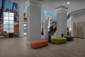 Un hall d’entrée spacieux avec un plancher en bois, un escalier et des peintures murales aux couleurs vives.