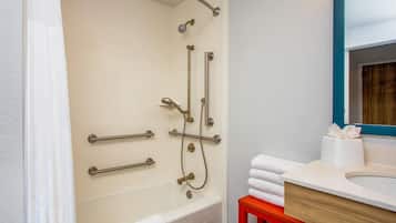 A bathroom with a bathtub, a shower, and a sink.