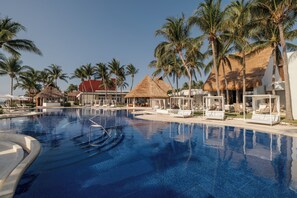Ein großer Pool mit Liegestühlen und Palmen.