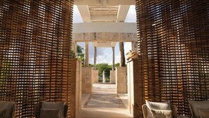 Un pasillo con vistas a un patio interior, que incluye una zona de estar con sofás y un diseño decorativo en el suelo.