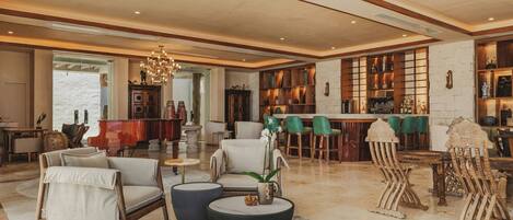 A spacious living room with a piano, comfortable seating, a bar area, and a chandelier.