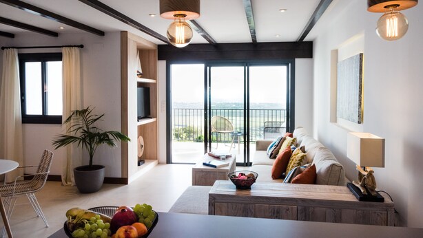 Ein modernes Wohnzimmer mit großem Fenster, Essbereich und Balkon mit Blick.