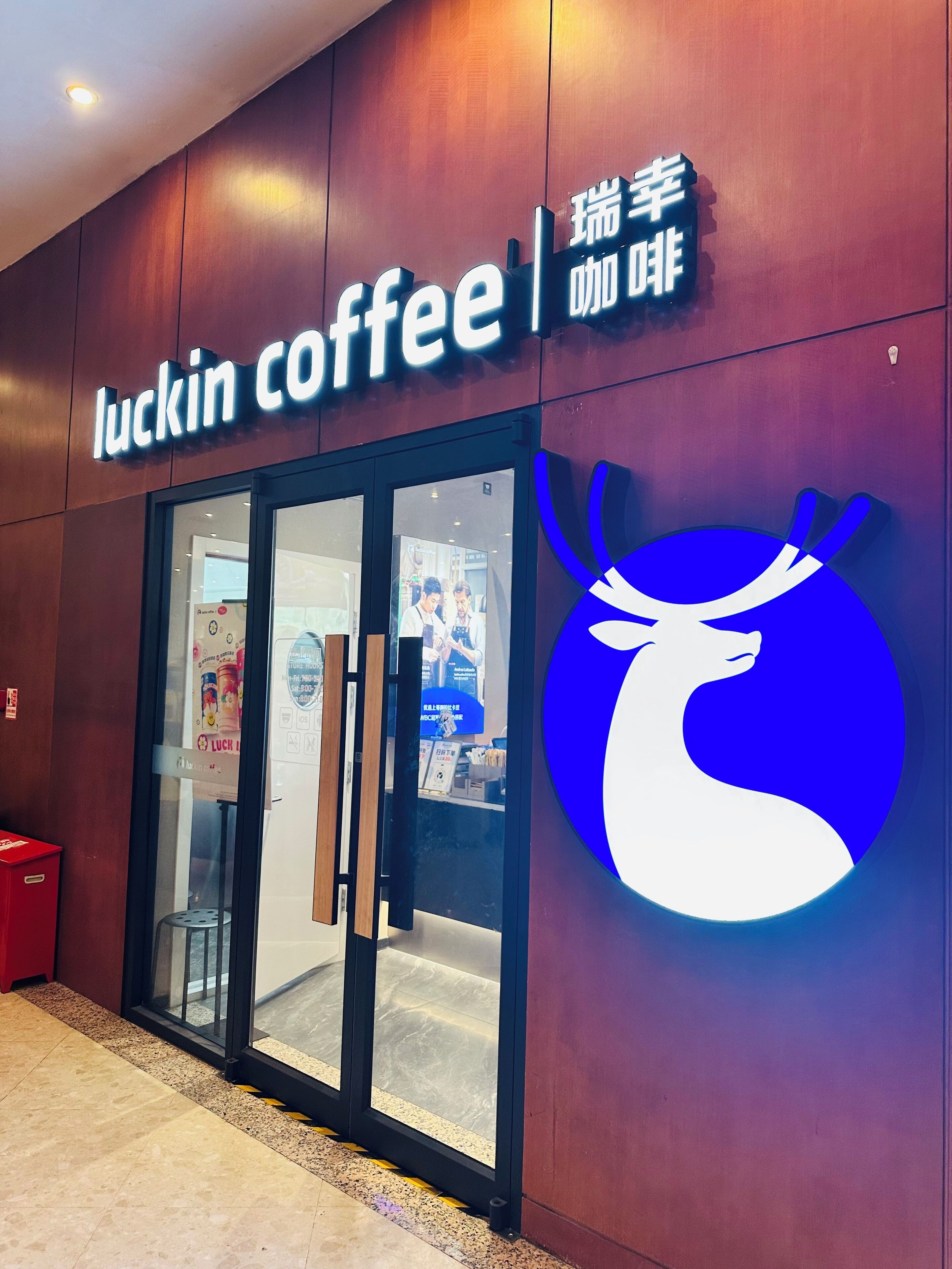 A coffee shop entrance with a neon sign and a stylized animal logo.