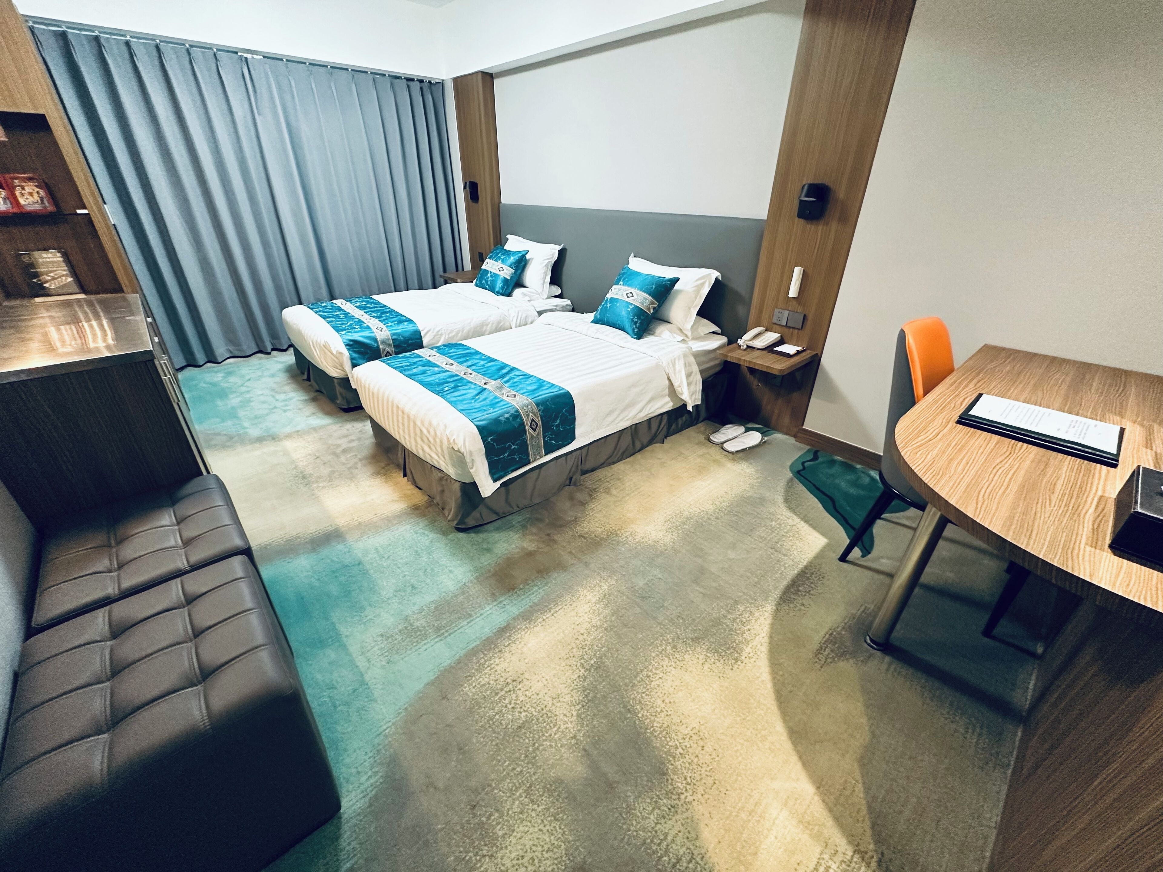 Una habitación de hotel con dos camas, un escritorio, una silla y una mesita.