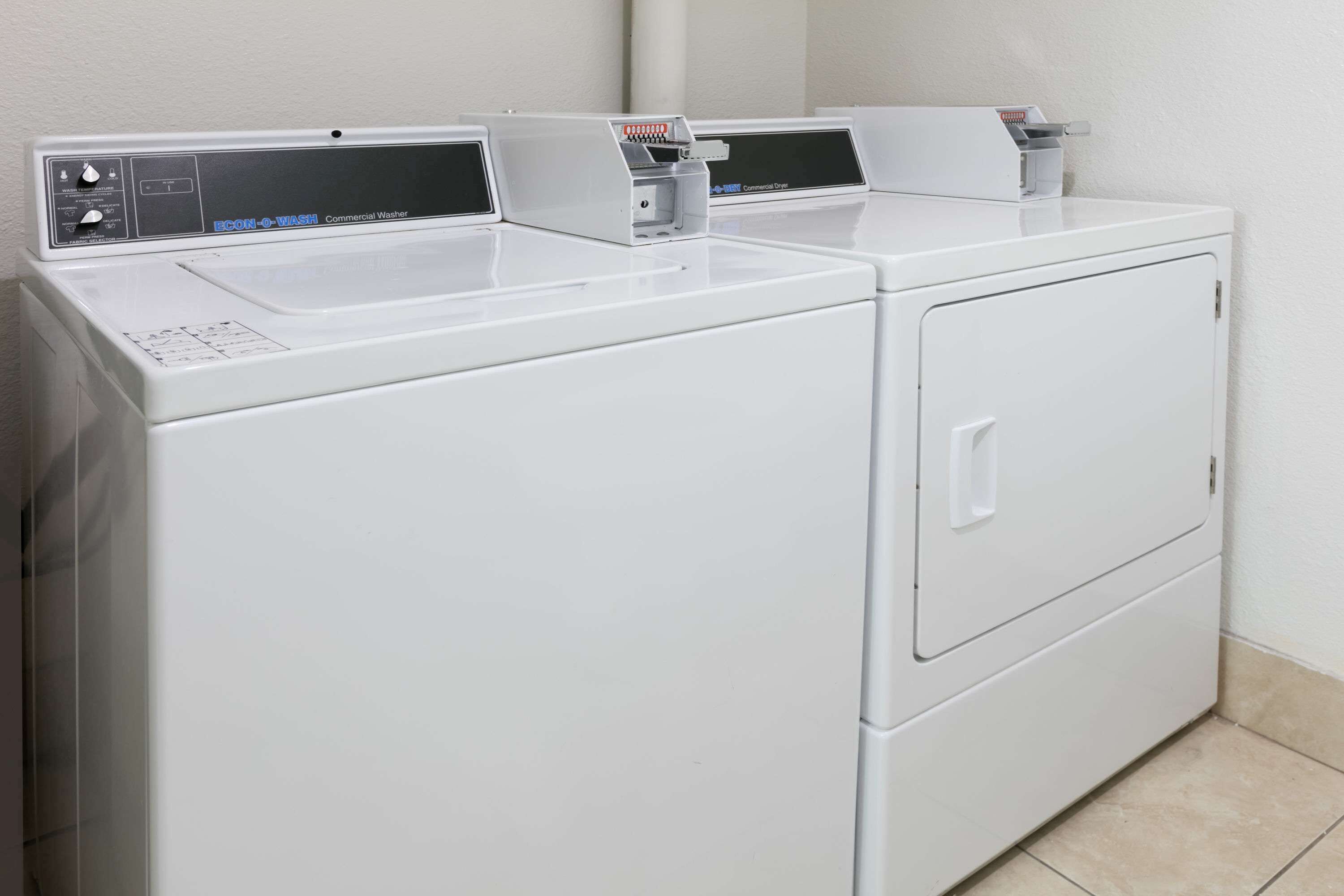 A pair of commercial washers with control panels and a front-loading door.