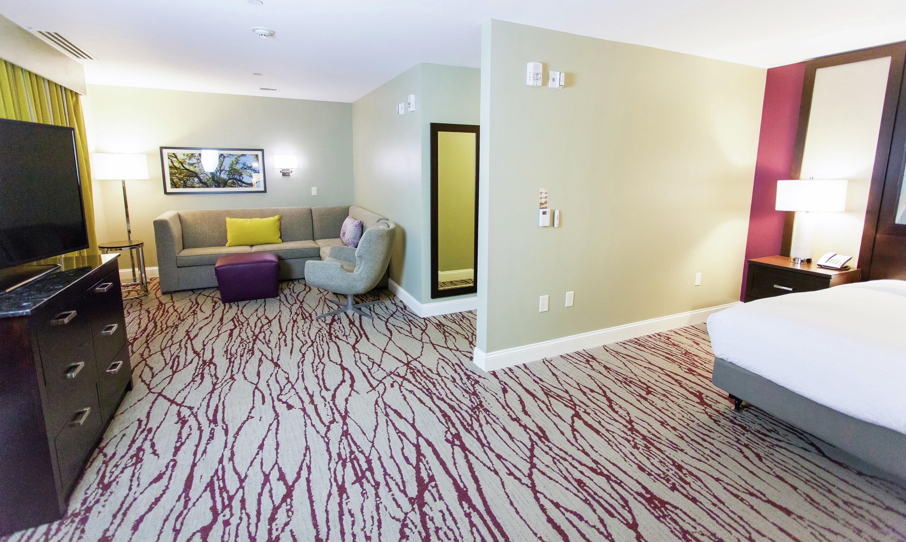 Habitación de hotel con sofá, sillón y cama.