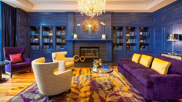 A library with bookshelves, a fireplace, and seating areas. - DoubleTree by Hilton Hotel Savannah Historic District (Savannah)