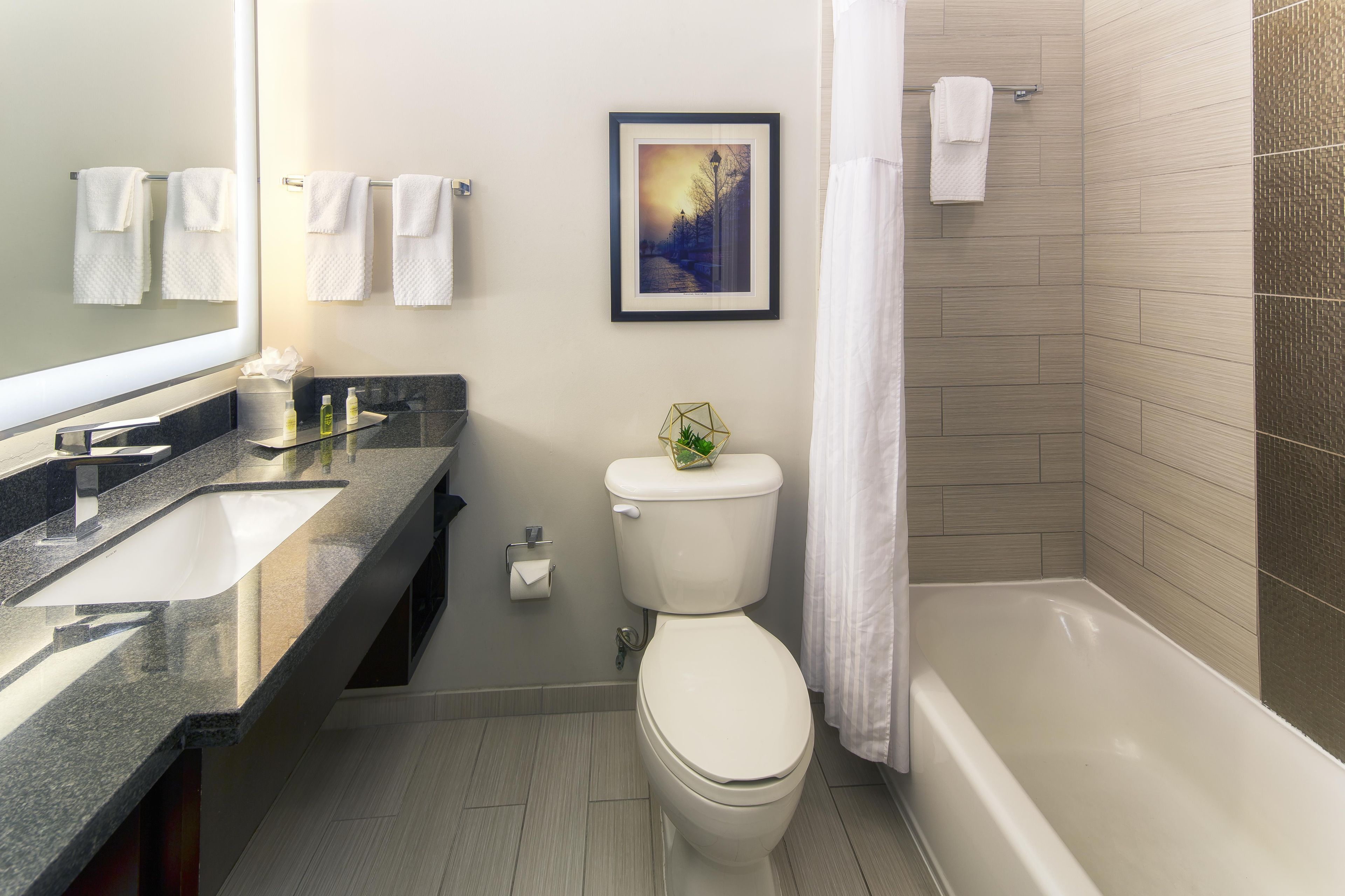 A modern bathroom with a toilet, sink, and bathtub.