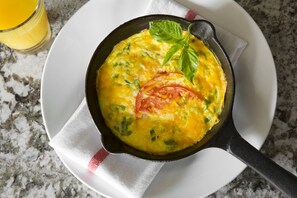 A skillet with a dish on a white plate, a glass of orange juice, and a white napkin on a granite countertop. - DoubleTree by Hilton Hotel Savannah Historic District (Savannah)