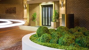A DoubleTree by Hilton hotel entrance with a brick facade, a well-lit entrance, and a landscaped garden area. - DoubleTree by Hilton Hotel Savannah Historic District (Savannah)