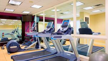 Ein Fitnessstudio mit Laufbändern, Crosstrainern und Gymbällen.