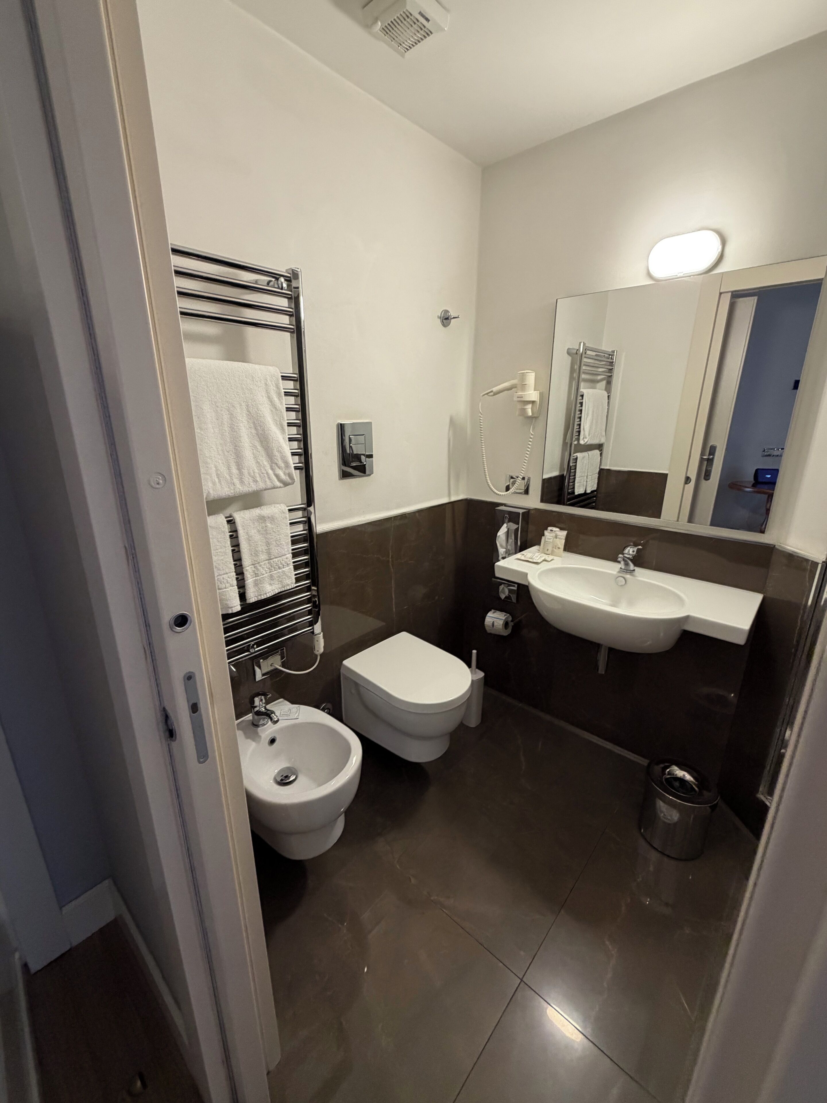 A modern bathroom with a bidet, toilet, and sink.