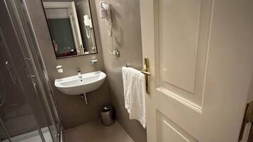 Un baño con ducha, lavamanos e inodoro.