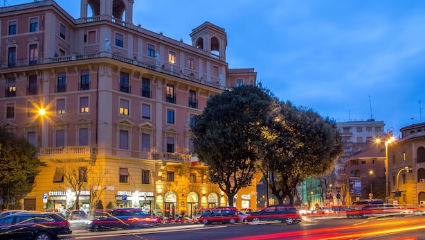 Um edifício histórico com vários andares, janelas amplas e uma entrada imponente.