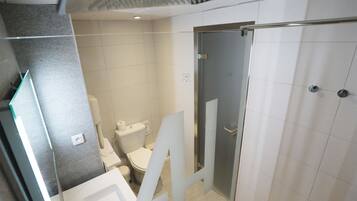 A modern bathroom with a toilet, sink, and shower area.