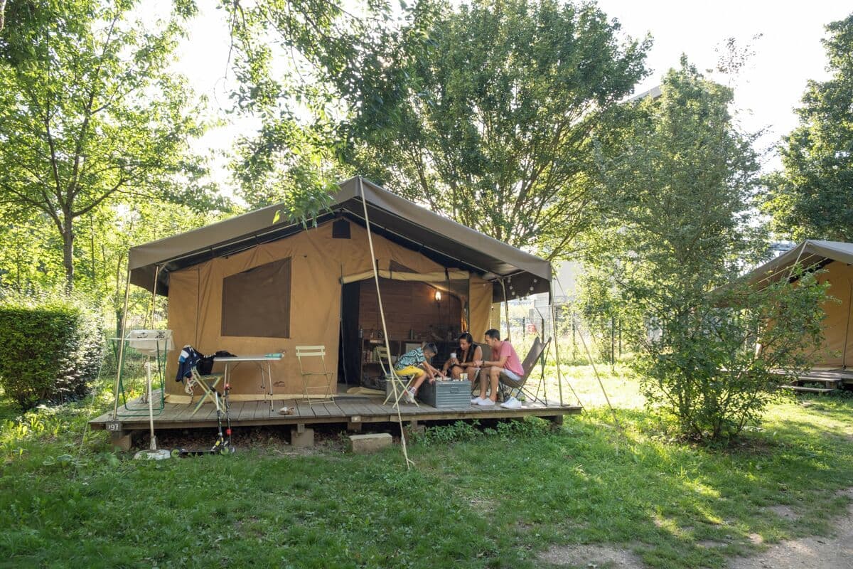 Une petite cabane à un seul étage, dotée d’une véranda et entourée d’arbres.