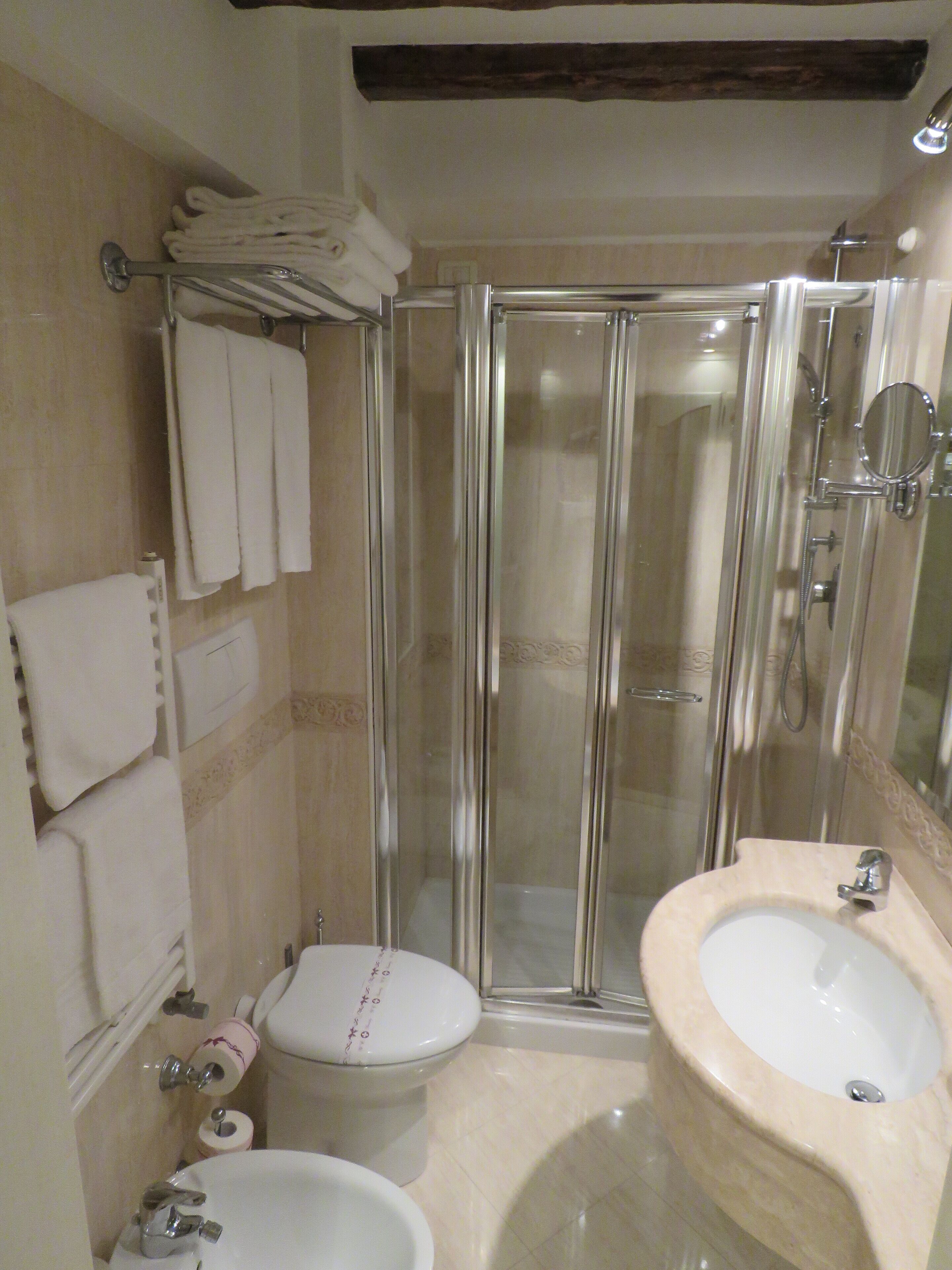 Une salle de bain avec une douche à parois de verre, des toilettes et un lavabo.