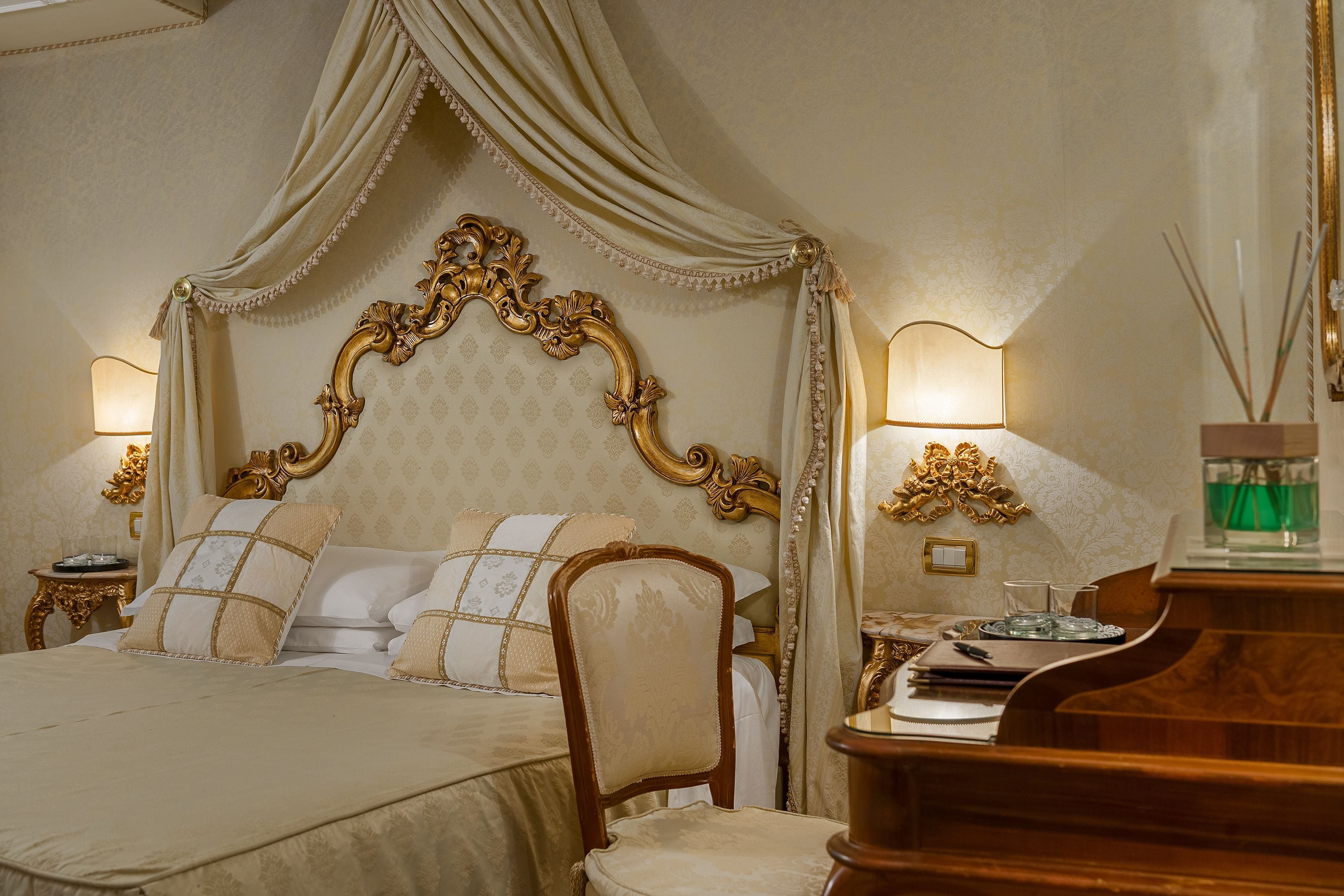 A luxurious bedroom with an ornate four-poster bed, a wooden chair, and a piano.