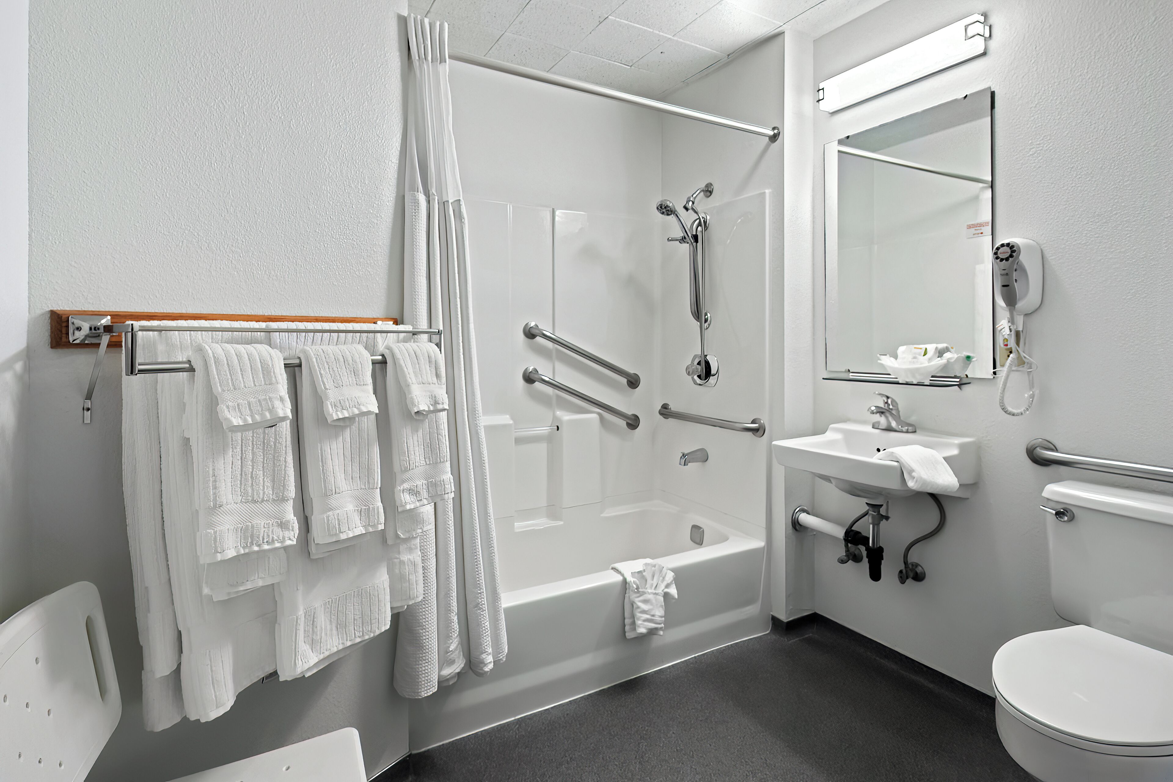 A modern bathroom with a bathtub, shower, toilet, and sink.
