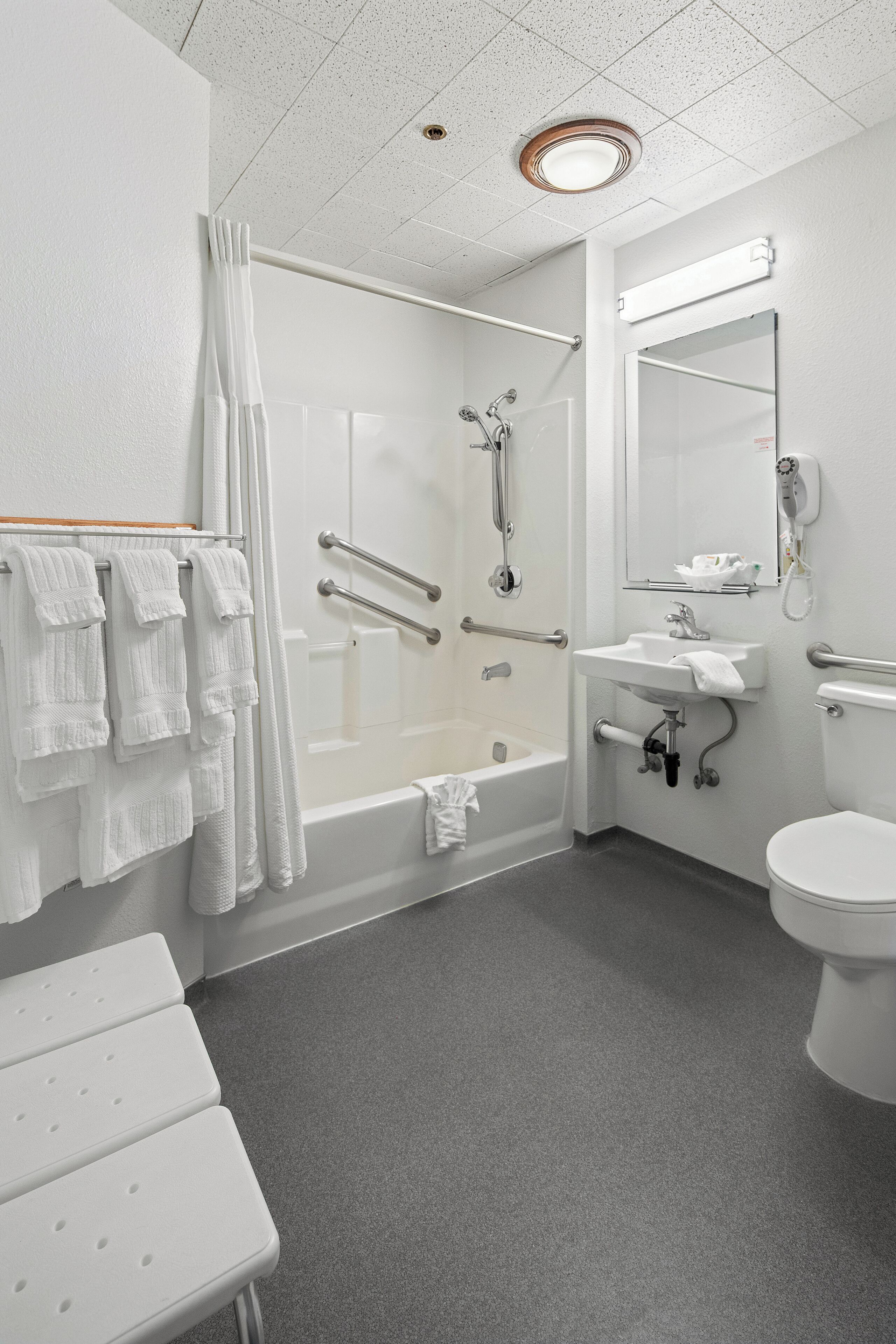 Une salle de bain moderne équipée d’une baignoire, d’une douche, de toilettes et d’un lavabo.