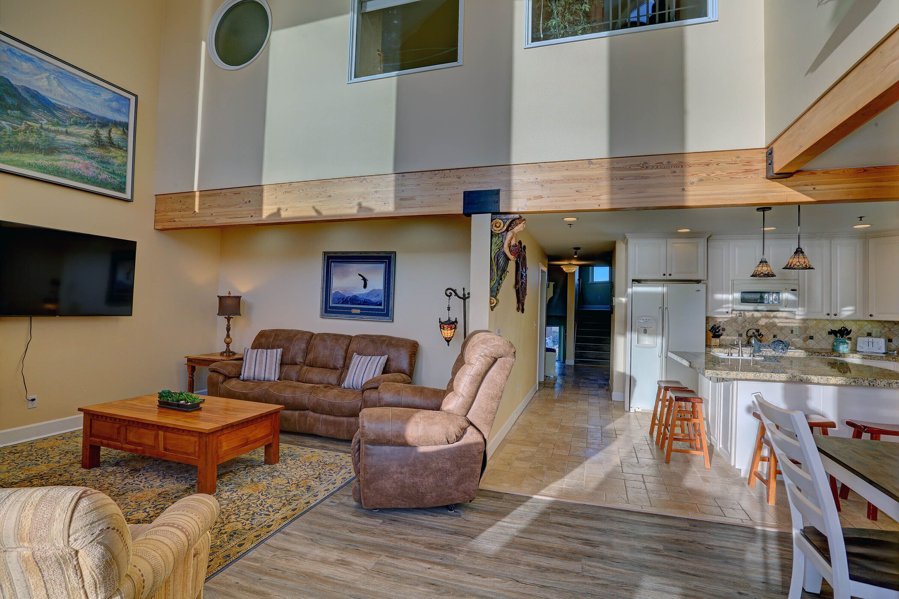 A spacious living area with a leather sofa, a wooden coffee table, and a patterned rug.