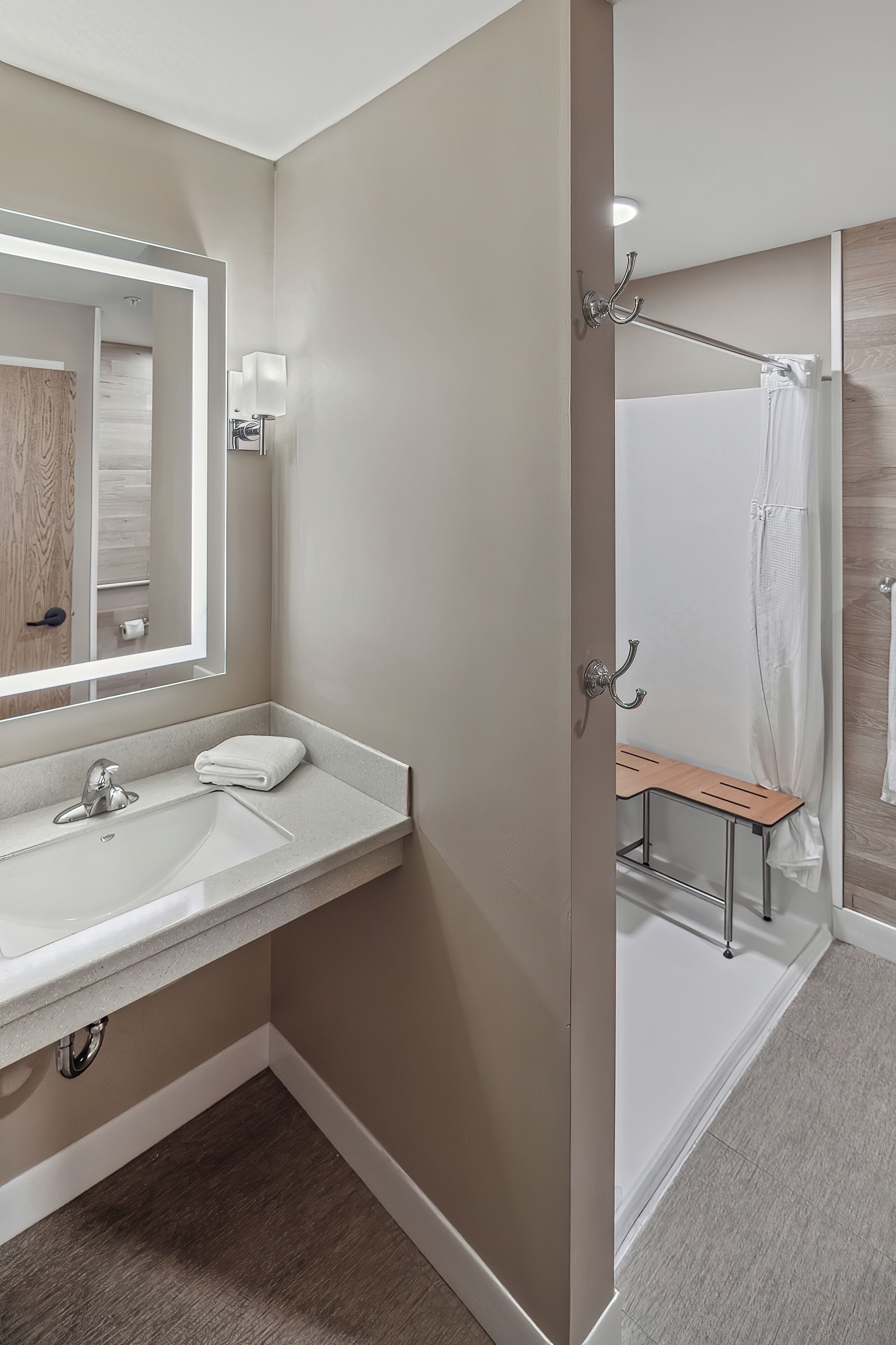 A modern bathroom with a large mirror, a sink, and a shower area.