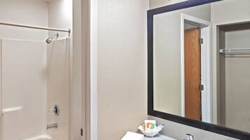 A bathroom with a bathtub, toilet, sink, and a large mirror.