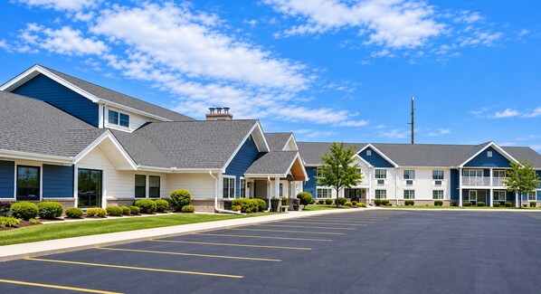A hotel with a parking lot and multiple buildings with a modern architectural style.