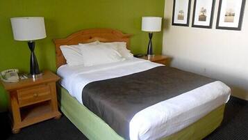 A hotel room with a bed, two bedside tables, a telephone, and framed pictures on the wall.