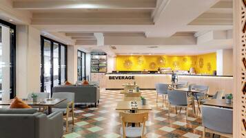 A modern cafe with a central beverage bar, seating areas, and a checkered floor.