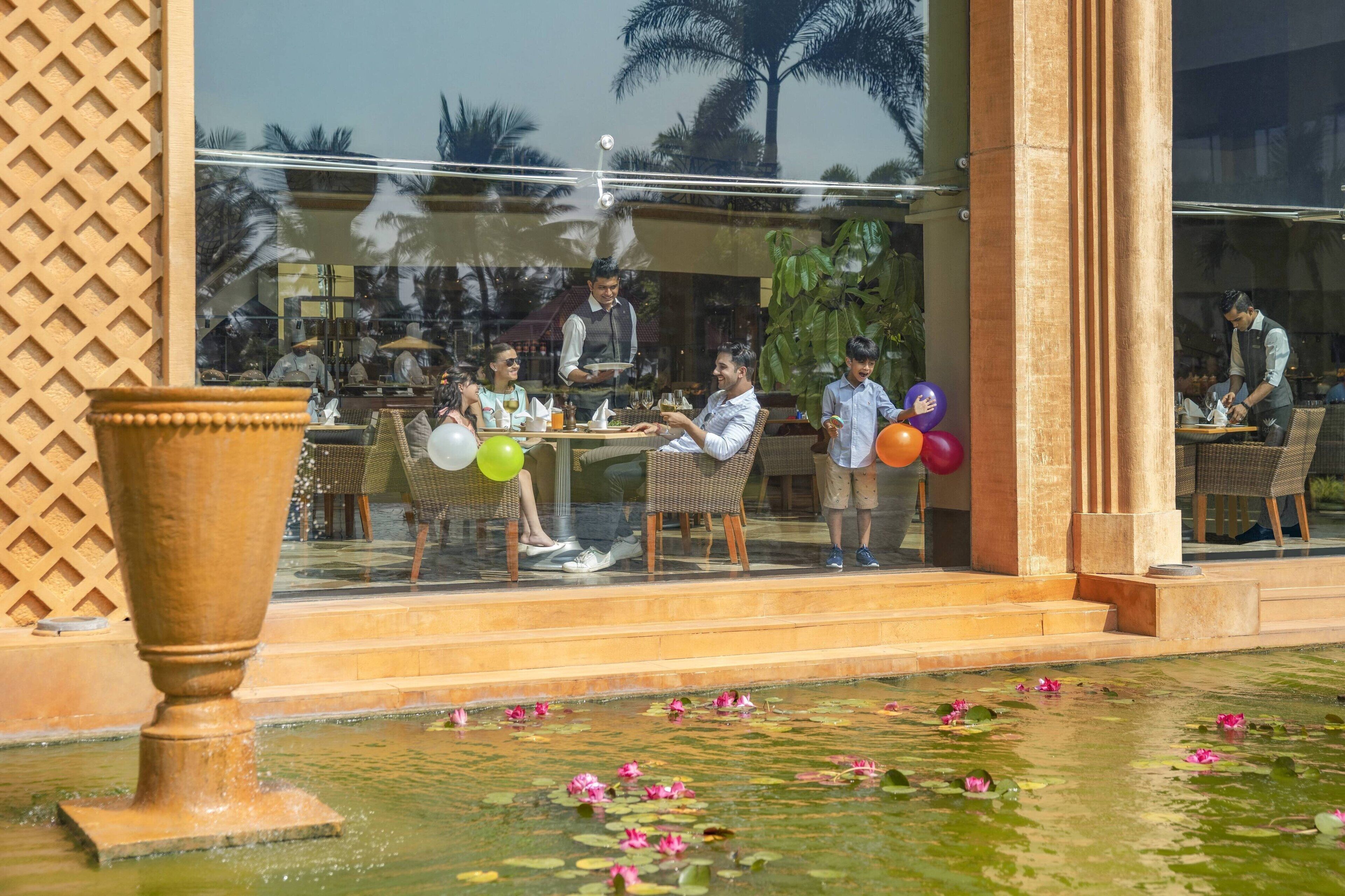 An outdoor dining area with a water feature in the foreground.