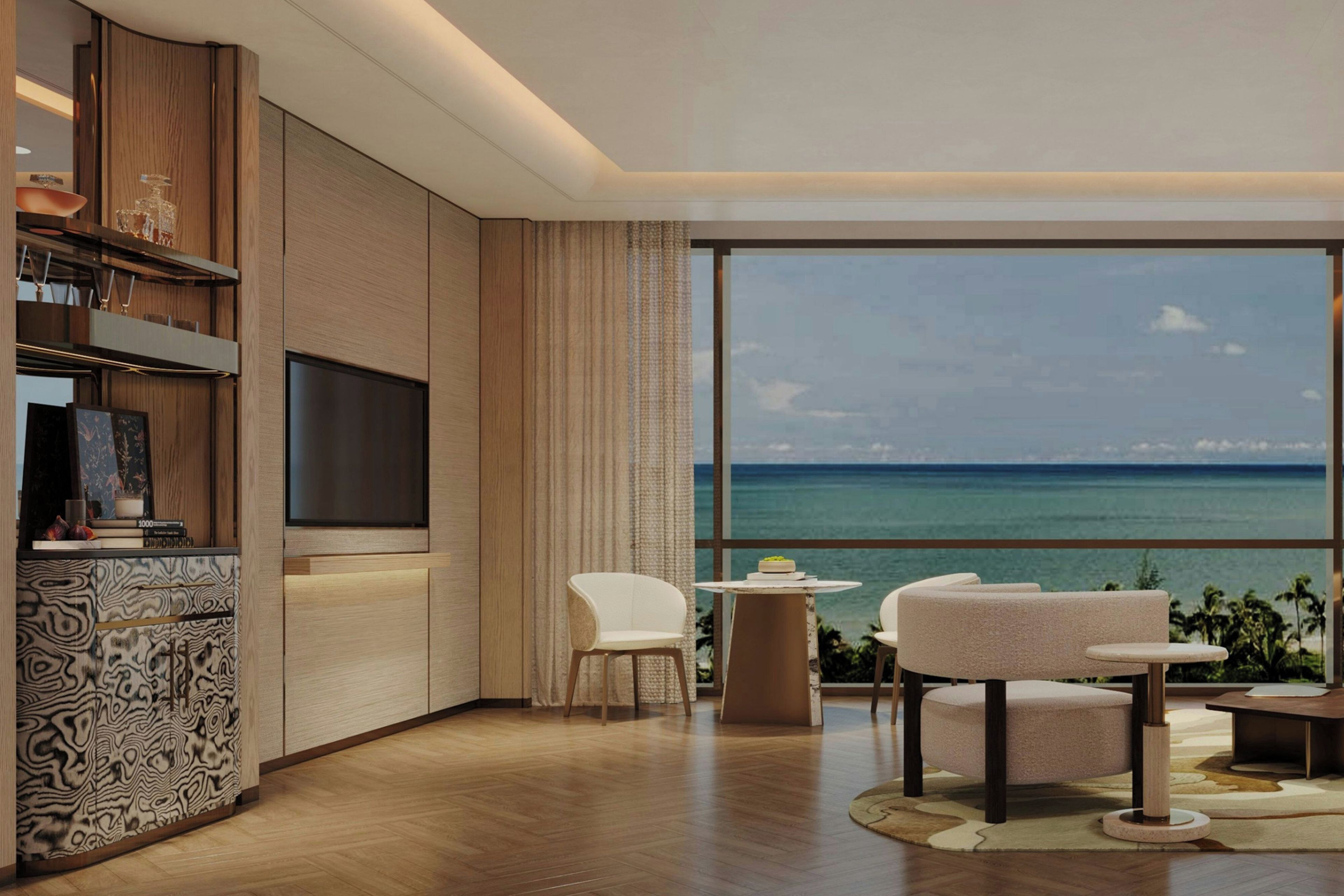 A modern living room with a large window overlooking the ocean, a flat-screen TV mounted on the wall, and a seating area with two chairs and a small table.
